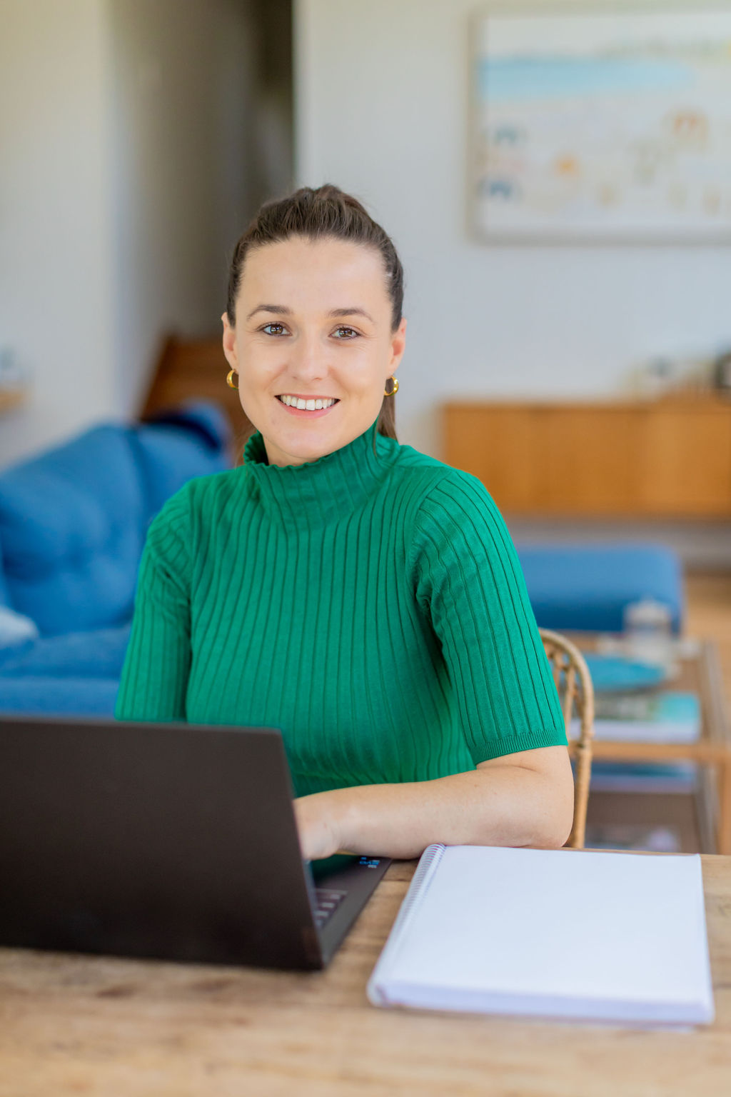 Kendall, founder of K&Co Socials, smiling at her laptop